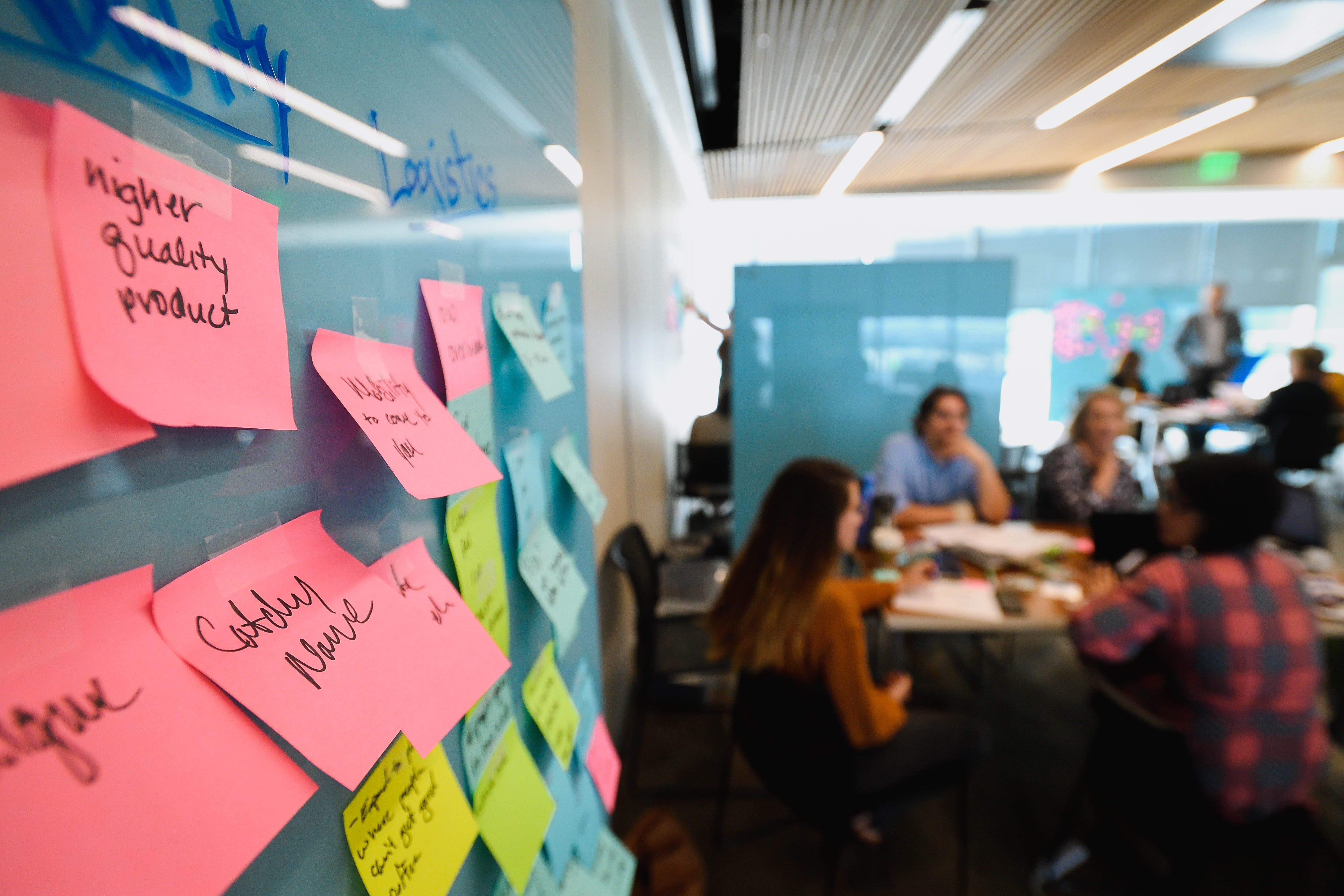 students brainstorming next to a wall during an experiential learning activity at johns hopkins carey business school