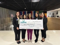 five students holding a large check