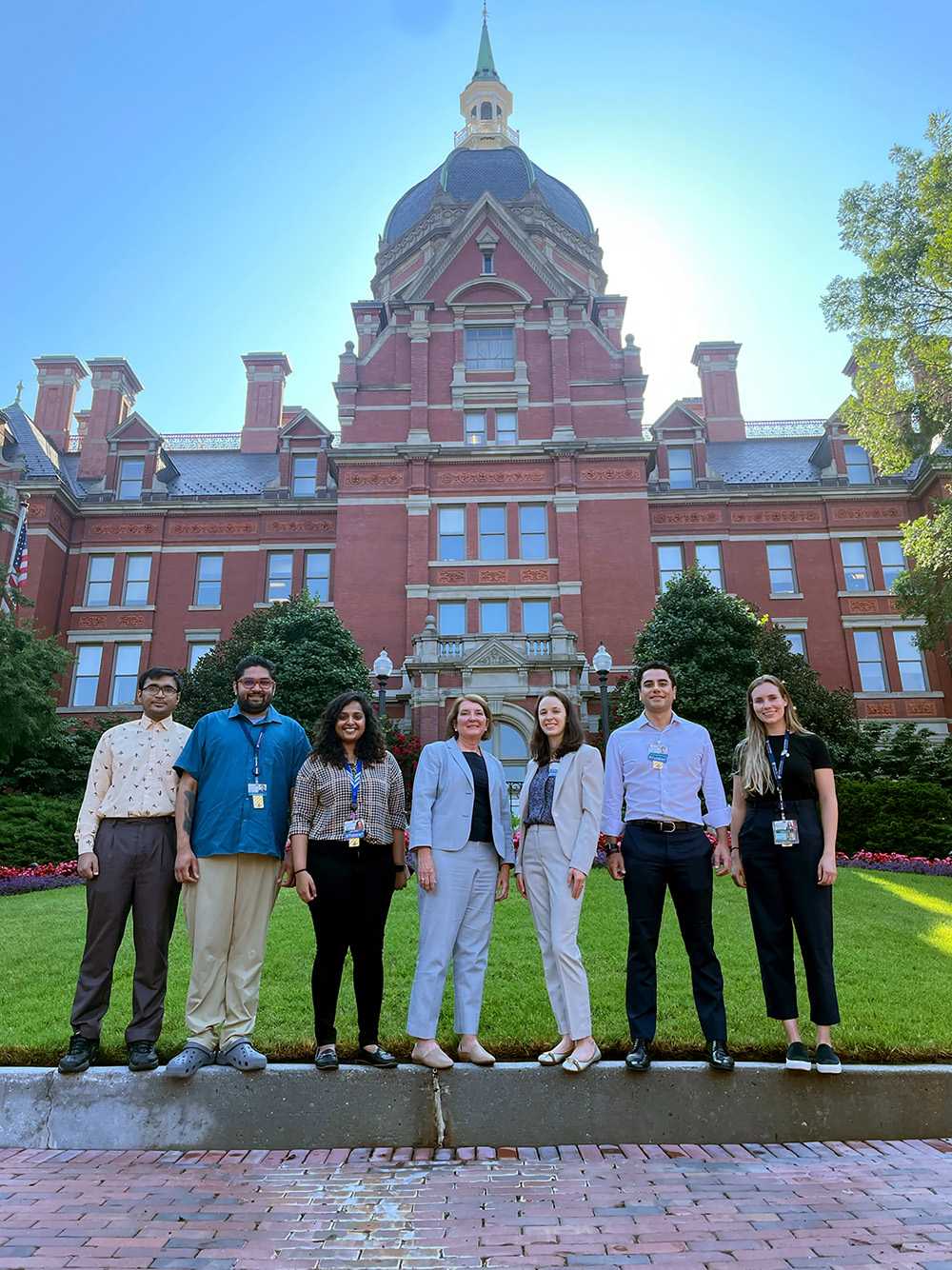 7 interns in front of JHU Hospital historic dome admin building