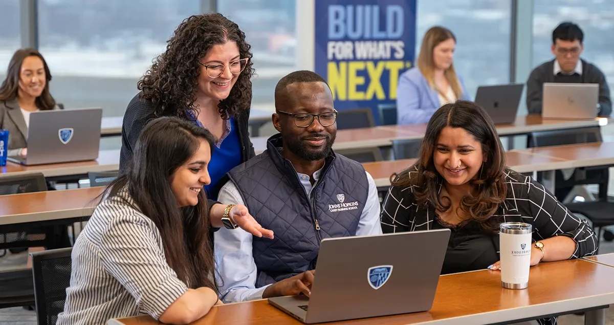 Students working together around a computer screen
