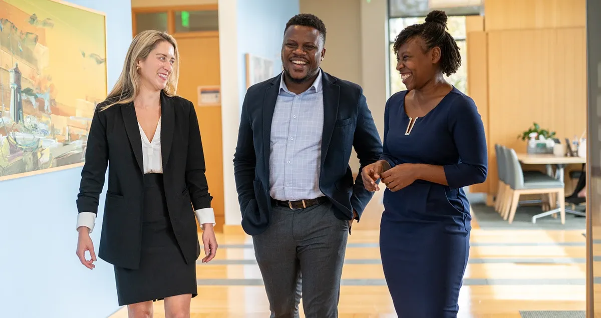 Three alumni walking in the hallway of Carey Business School