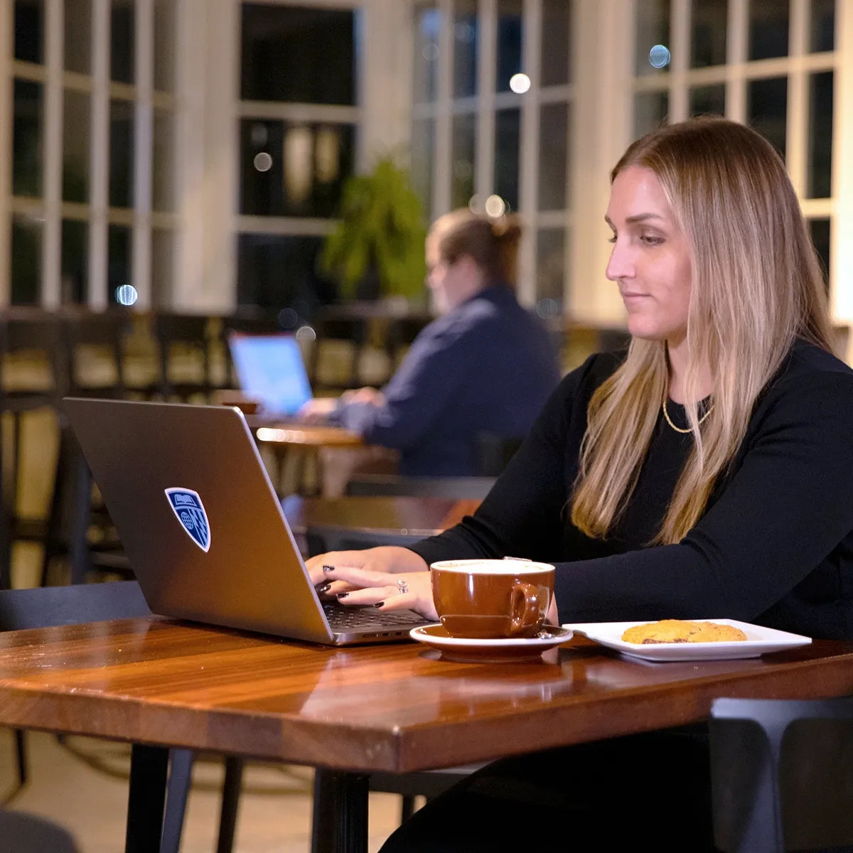 Student working on computer at a coffee shop