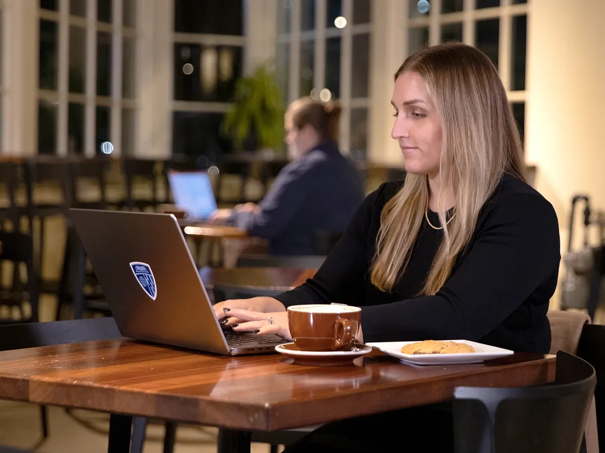 Student working on computer at a coffee house.