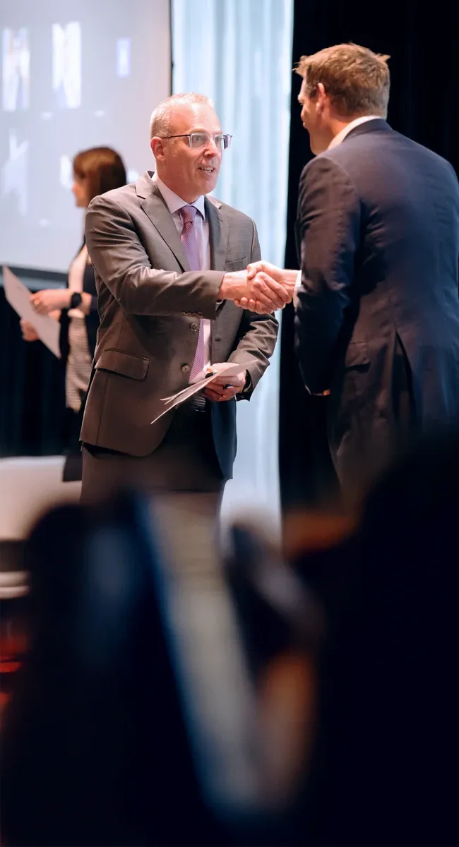 Participant shaking hands with Carey Business School leader