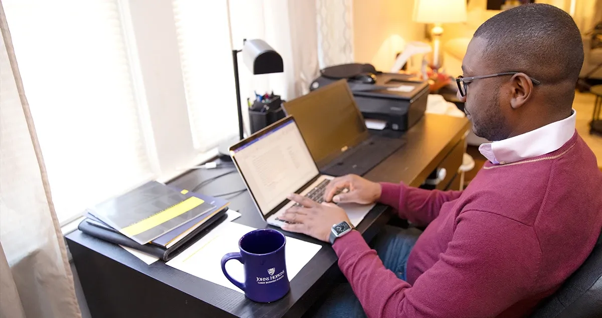 Student working remotely from desk in a home.