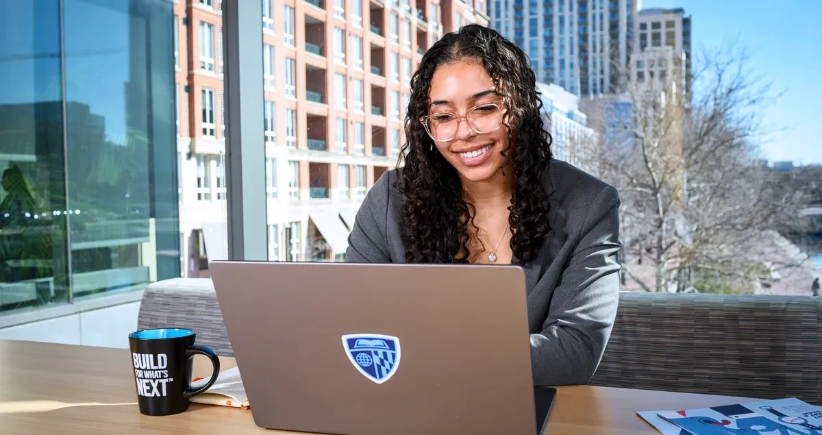 Student working at computer with a smile