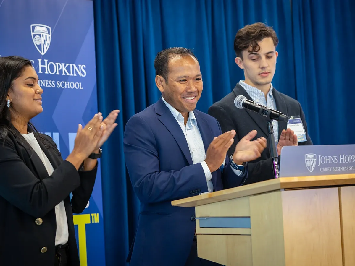 three people at a podium at a conference