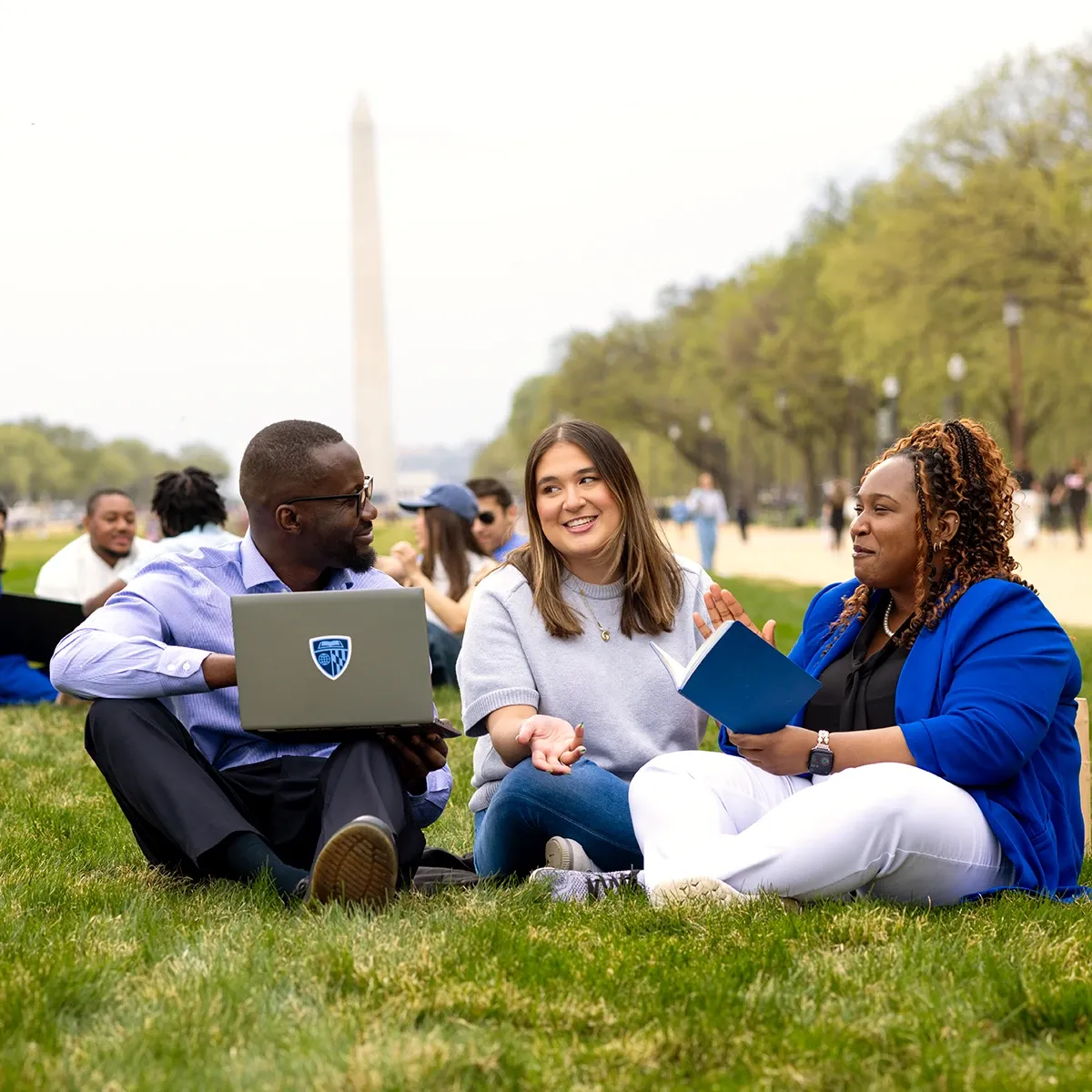 Students sitting on the lawn in front of the Washington Monument