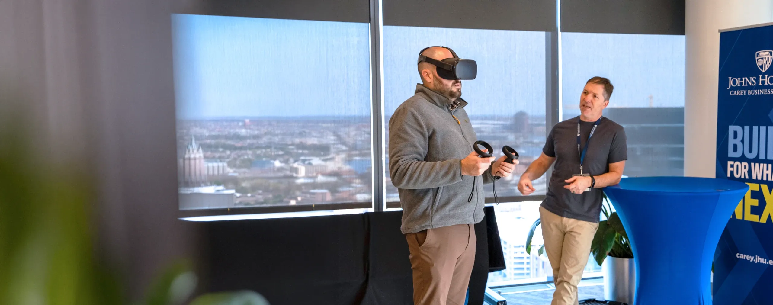 Faculty working with VR goggles with instruction from teaching and learning staff