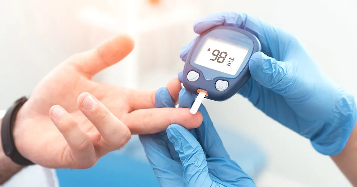medical gloved hand taking a blood sample from a patients finger