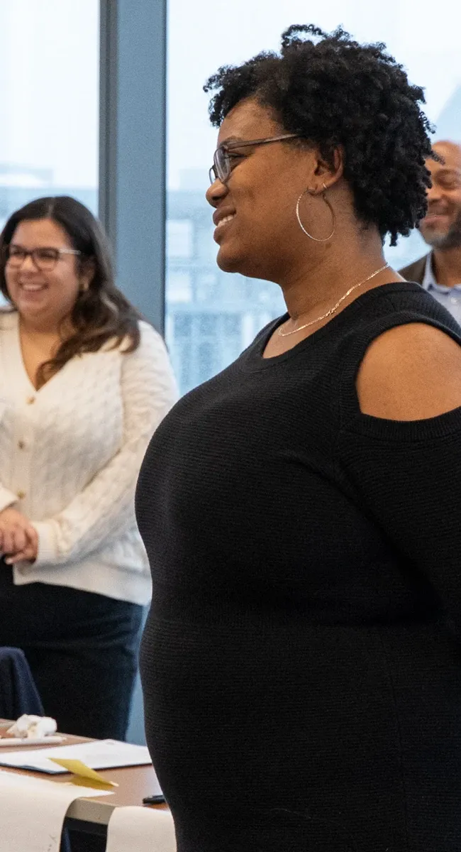 Participants smile during a collaborative classroom activity at Johns Hopkins Carey Business School.