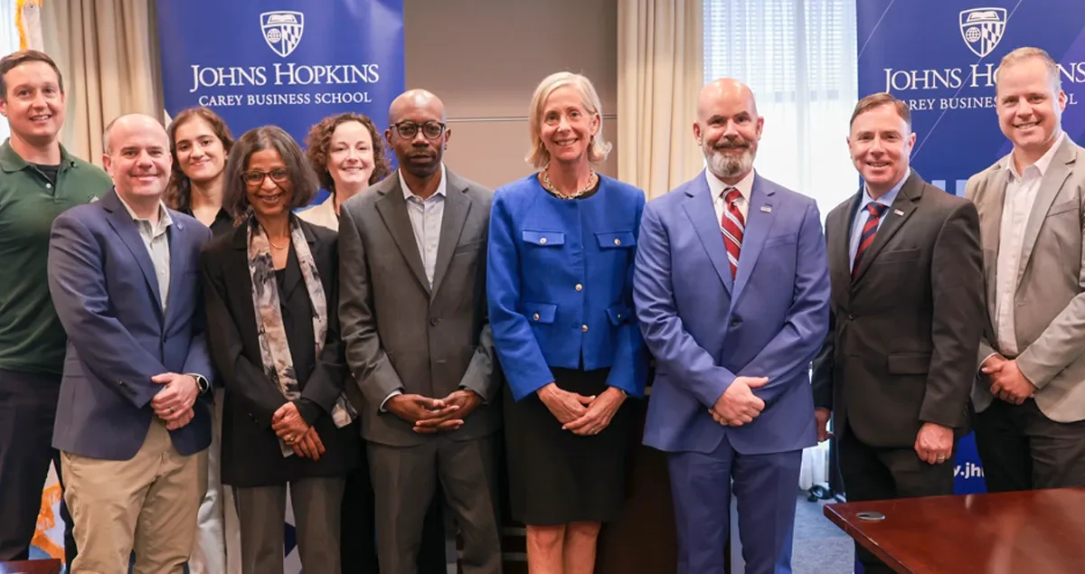 Group of professionals posing for photo at Johns Hopkins meeting room.