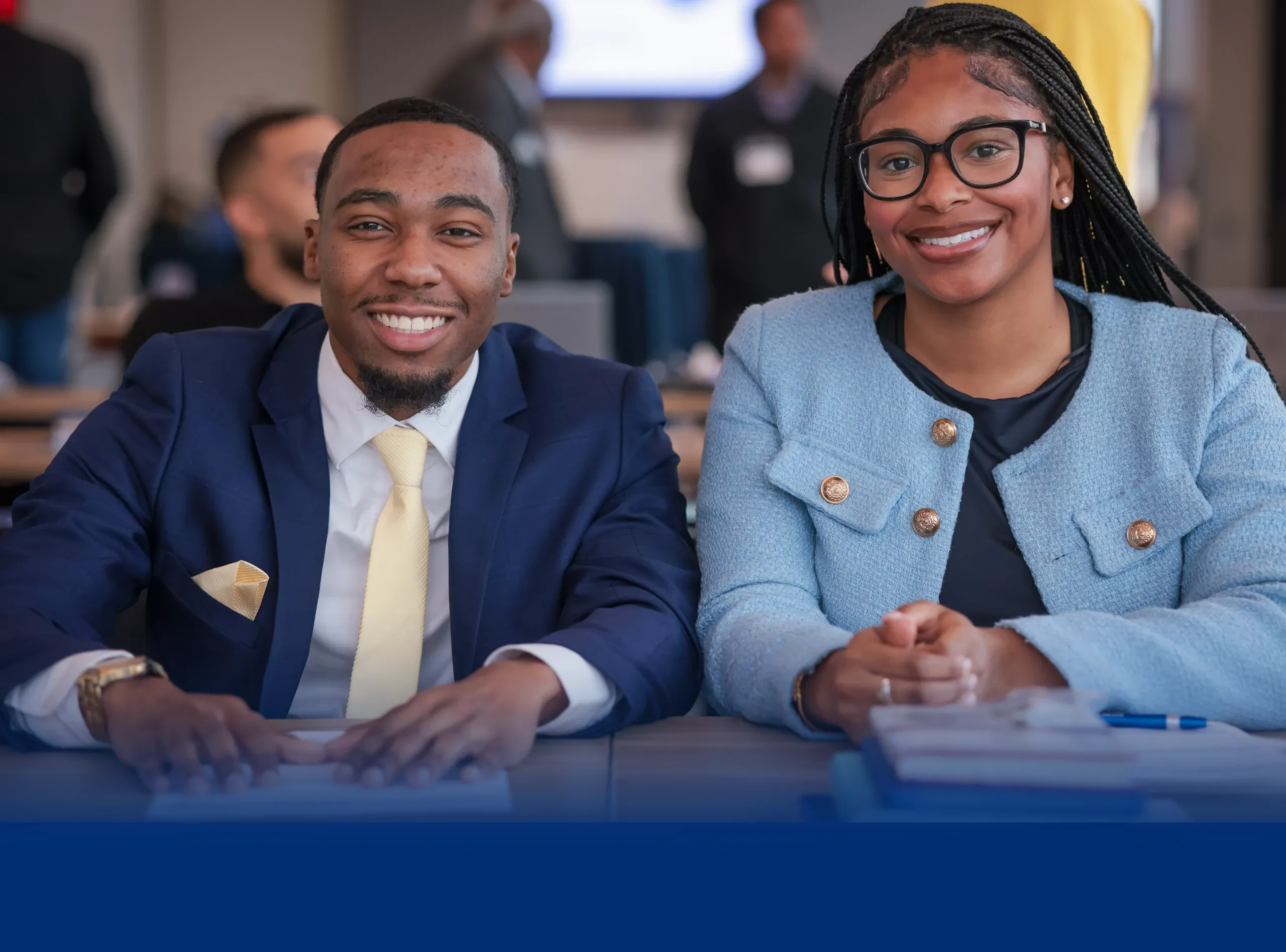 Smiling students seated at a conference table