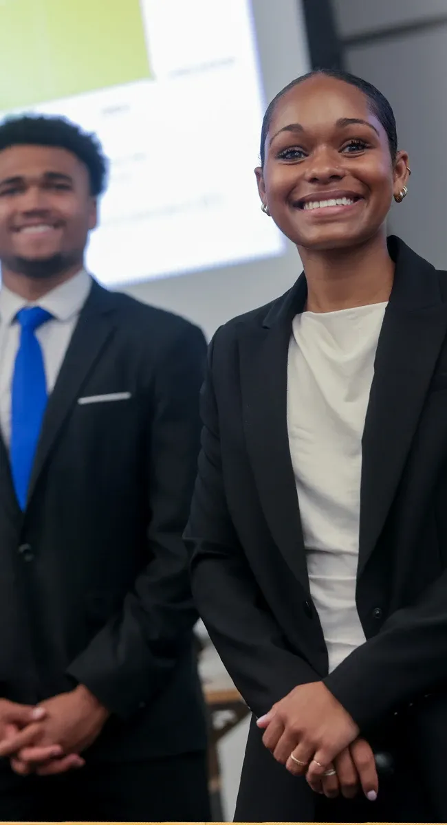 Smiling young students presenting in a classroom
