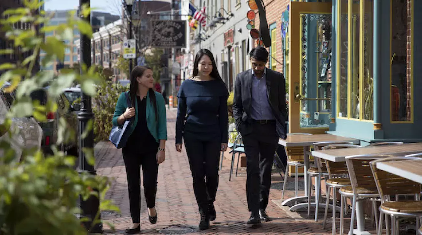 students walking on the cobblestone sidewalk near the baltimore campus of johns hopkins carey business school