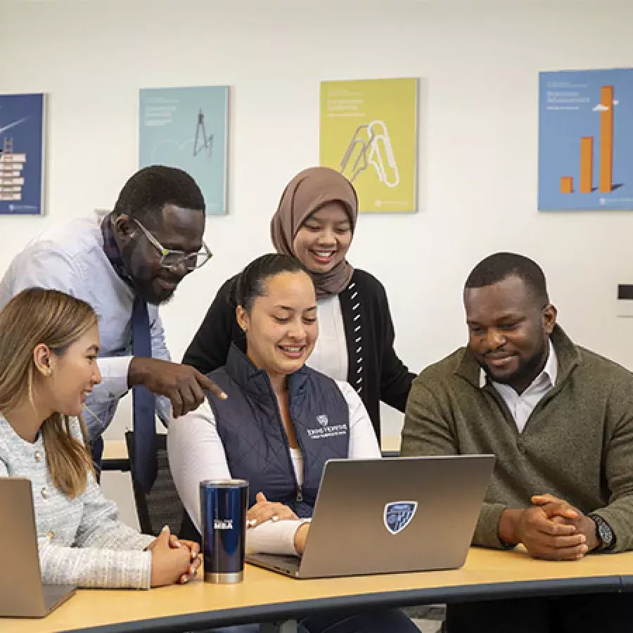 5 students around a laptop