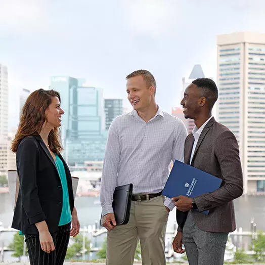 carey business school students stand and talk at federal hill in Baltimore 