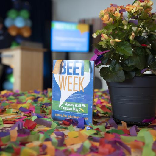 Beet Week poster with a flower post and petal scattered on the table.