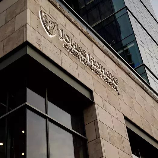 JHU Carey Business school front facade with logo at twilight