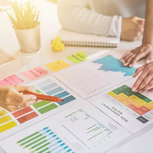 three people at a table pouring over charts and graphs