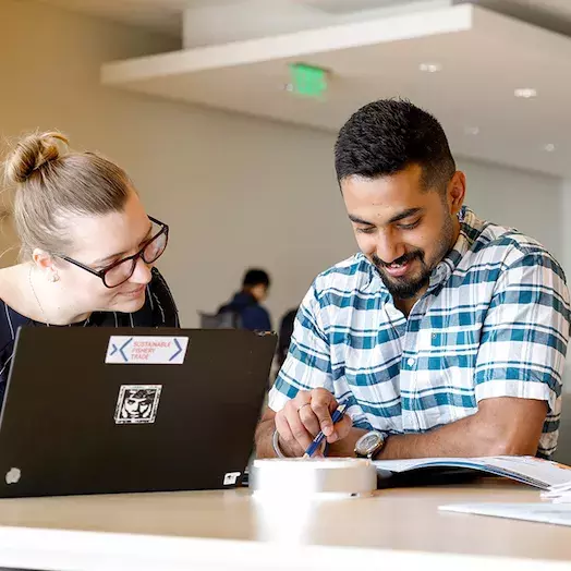 a couple of students in a room at Carey going over a document