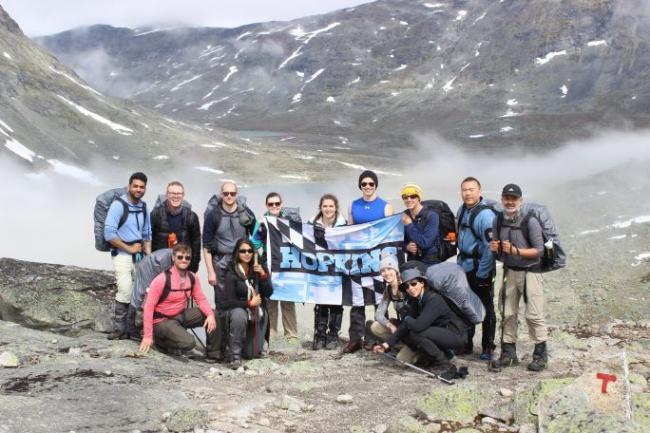 students with hopkins flag in the mountains
