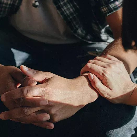 clasped hands with consoling touch