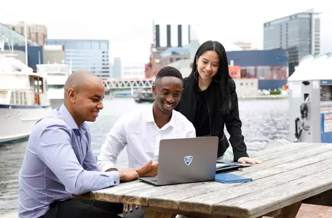 students working at a computer together while they focus on their Flexible MBA concentration in entrepreneurship