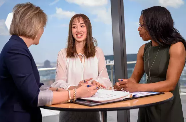 a jhu carey business school student discussing her classes with two of hero mentors through the NEXT approach