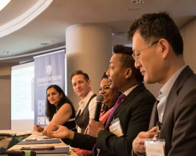 panelists sitting speaking into microphone