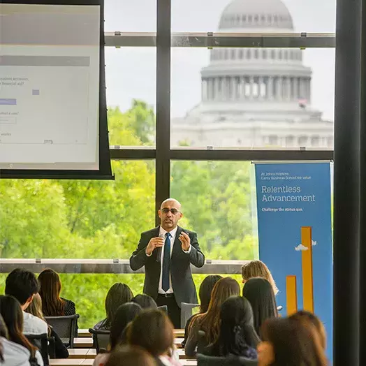 speaker in front of an audience capital building in the background