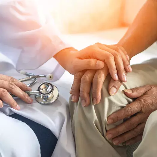 doctor's hand holding patient's hand