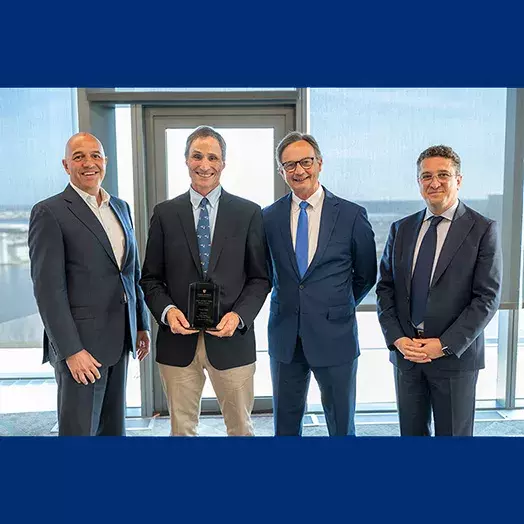 Dean Alex Triantis, David Godes and 2 other professors posing with Carey window in the backgound