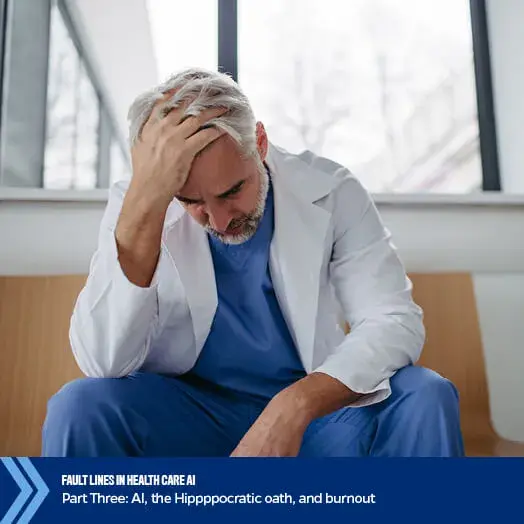 Stressed doctor in white coat sitting with head in hand