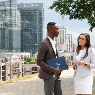 two students in the MBA program at the Carey Business School talking outside of Federal Hill in Baltimore MD