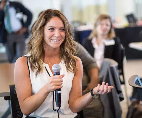 woman student holding a microphone making a comment