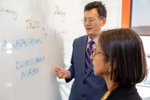 ritu agarwal and gordon gao at whiteboard