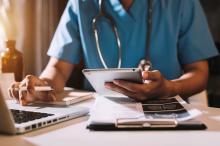 doctor with laptop article doctor in scrubs at laptop with tablet