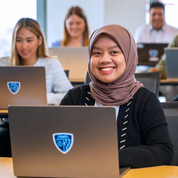 Student smiling and working on computer